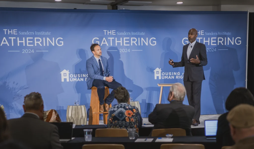 Joe Bishop and Tyrone Howard speaking on stage.