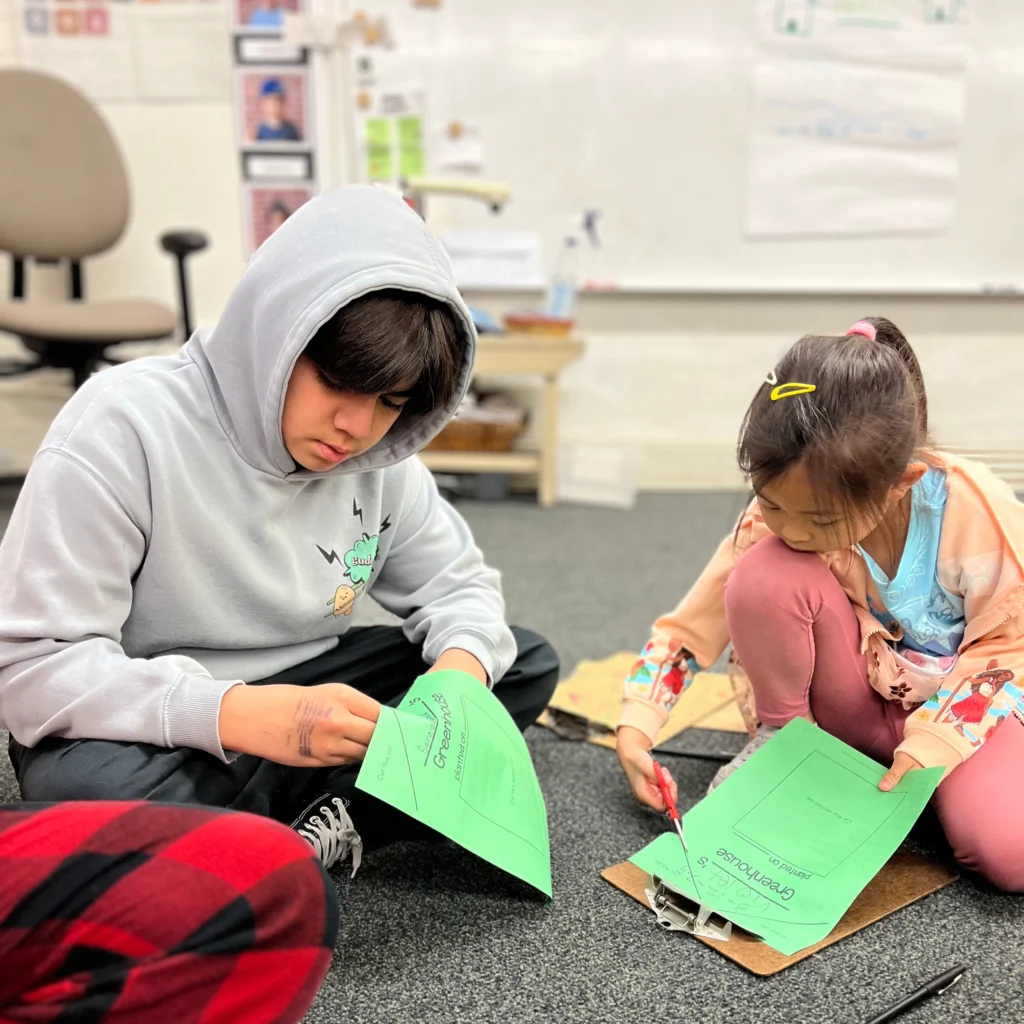 Students cutting out paper together